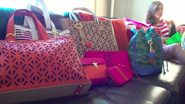 Close-up view of colorful bags on a sofe with a background of a Caucasian woman sitting