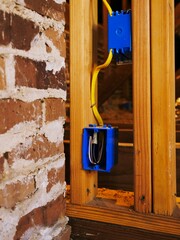 Blue box filled with electrical wires, arranged against a window