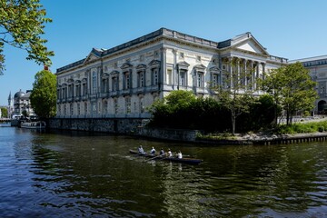 Fototapeta na wymiar Scenic view of the majestic Appeals Court House in Ghent with people rowing on the water nearby