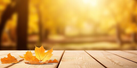 Naklejka na ściany i meble Wooden planks and orange dry leaf against the background blurred tree foliage of trees in beautiful autumn park. Autumn universal background for presentation