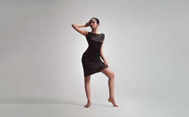 Model posing ethereal dance in isolated grey background