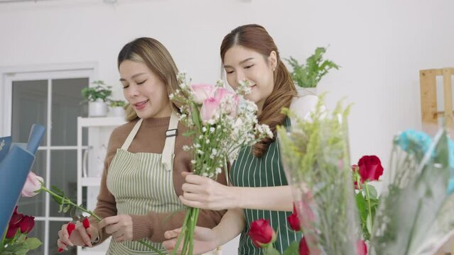 Two beautiful Asian florists work together in her own shop. Small business, Owner business.
