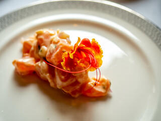 Tartare Mediterranean style menu in luxury hotel restaurant, decorated with fresh colorful flower...