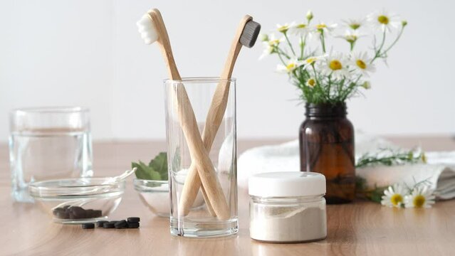 Put the wooden toothbrush and toothpaste on the table in the bathroom. Zero waste concept. Eco-friendly bathroom accessories. Natural cosmetics, beauty and eco life concept in cozy bathroom