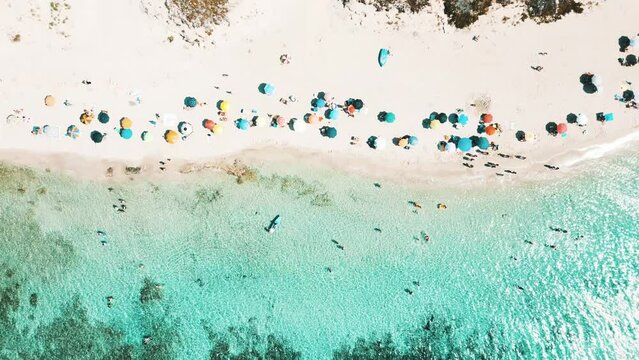 vista aerea della meravigliosa spiaggia dalle acque turchesi cristalline, con gli ombrelloni colorati, in estate . Salento, marina di Lizzano, Taranto, Puglia, Italy