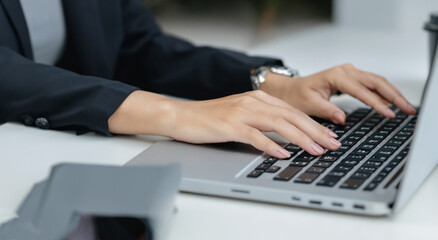woman in a suit in front of a computer writing
