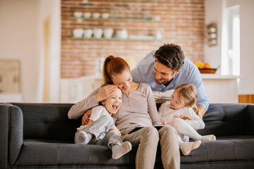 Young family using a tablet while sitting on the couch in the living room