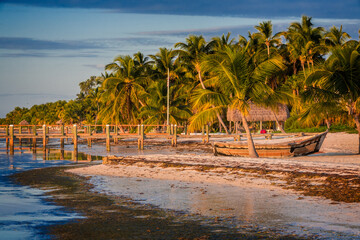 Coast line of Key West with wooden boat pulled up onto the sand