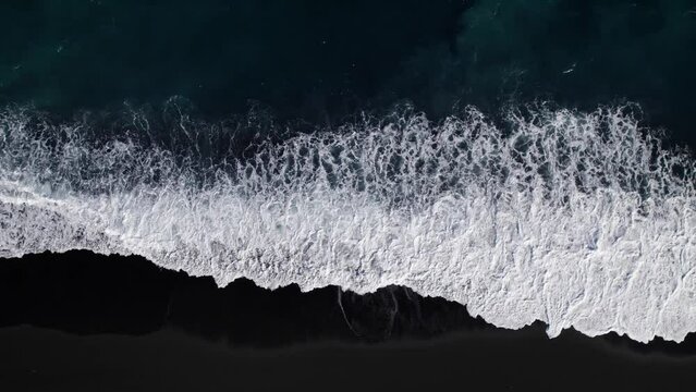 Black volcanic rock beach at Bali with White Ocean Waves drone DJI Mavic bird eye view top down