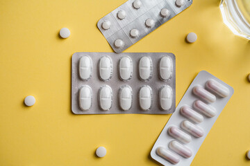Some pill blister packs on a yellow background. Pharmacy industry concept.
