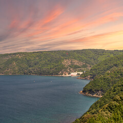 Fototapeta premium View from the top of mountains of Anadolu Kavagi, Bosphorus Strait, Istanbul, Turkey, with green woods, calm sea, and clear sky at sunrise time