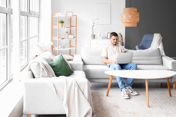 Young man using laptop on his day off at home