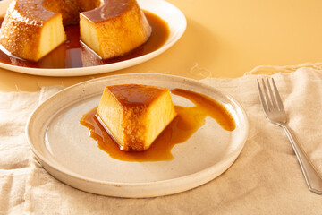 Creme Caramel Condensed Milk Pudim slice in front view with beige background