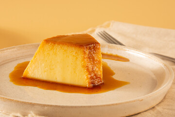 Creme Caramel Condensed Milk Pudim slice in front view with beige background