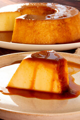 Creme Caramel Condensed Milk Pudim slice in front view with wood background