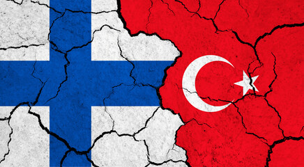Flags of Finland and Turkey on cracked surface - politics, relationship concept