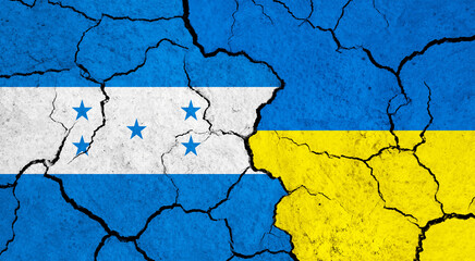 Flags of Honduras and Ukraine on cracked surface - politics, relationship concept