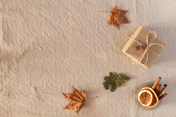 Autumn composition with autumn dry leaves, a gift wrapped in kraft paper, laid out in a corner on a...