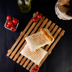 Toasted panini with ham, cheese and arugula sandwich on cutting board.jpg
