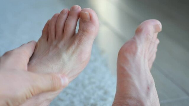 A man kneads his feet, close-up
