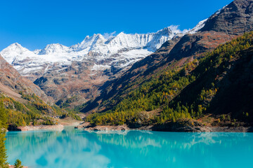 Autumnal landscape of the Lake Place Moulin, an artificial glacial lake with turquoise water in the italian Alps,  on the border with Switzerland