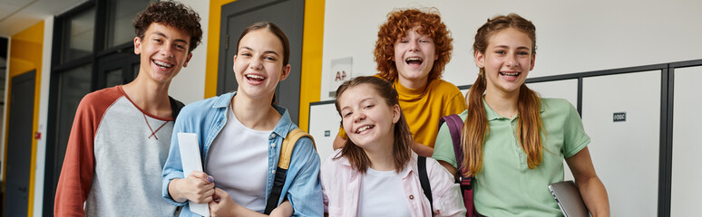 banner, teenage schoolkids looking at camera and standing in school hallway, teen classmates © LIGHTFIELD STUDIOS