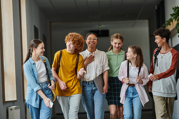 Fototapeta premium back to school, cultural diversity, teacher and teenage students walking in school hallway, smile