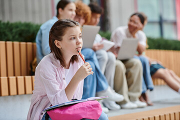 back to school, pensive girl holding pencil near mouth, taking notes, thinking, blur, study