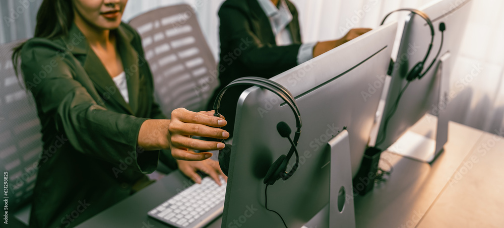 Aufkleber panorama focus hand holding headset on call center workspace desk with blur background of operator t