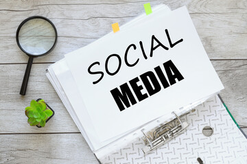 white sheets of paper in a file.wooden background. text on paper. Social media