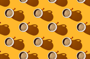 Pattern of coffee mugs on yellow pastel background