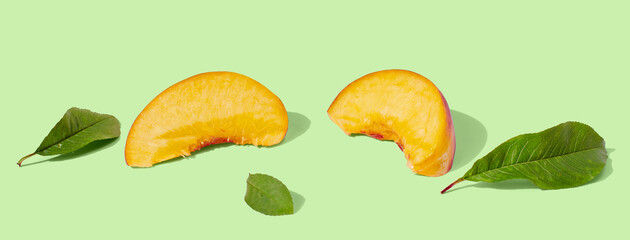 Nectarine slice on green pastel background