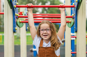 portrait of a happy smiling girl 6 years old playing on a children's playground.looks at the camera close-up