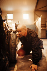 Fototapeta na wymiar Experienced male mechanic working in a car mechanics shop