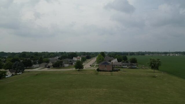 This shot starts over an empty retention pond for a residential neighborhood, then lifts as it approaches the neighborhood. 
