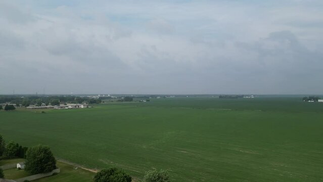 This shot pans from left to right starting at the edge of a residential neighborhood and moving to view the neighboring soy and farm fields.