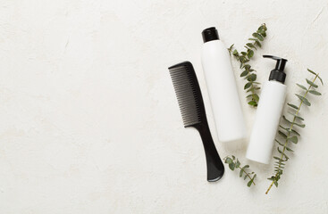 Professional hair care products with comb on concrete background, top view