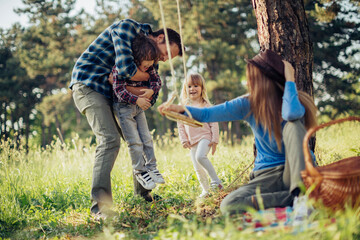 Young family having a picnic on a field in the forest