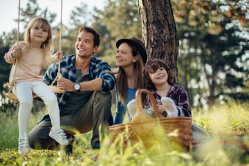 Young family having a picnic on a field in the forest