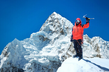 A climber stands on a snowy peak in Nepal. Everest region, National Park, Nepal.