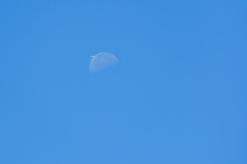 Daily Moon with plane in the blue sky