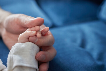 Asian parent hands holding newborn baby fingers, Close up mother's hand holding their new born baby.
