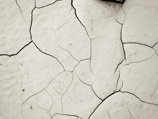 Obraz premium White peeling paint on the wall. Old concrete wall with cracked flaking paint. Weathered rough painted surface with patterns of cracks and peeling. Grunge texture for background and design.