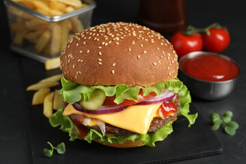 Delicious burger with beef patty on dark table, closeup
