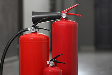 Three red fire extinguishers in hall. Space for text