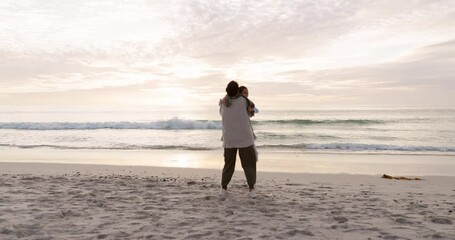 Grandmother, child and family hug at beach for fun vacation, holiday or adventure at sunset. Girl kid running to senior woman at ocean for quality time or embrace with love and care outdoor in nature