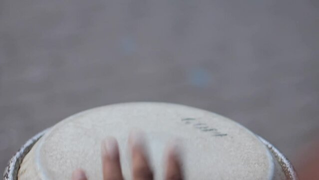 detail of hands playing timbal percussion instrument