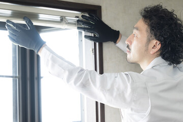 Interior decorating business man maintaining curtain rails and windows.