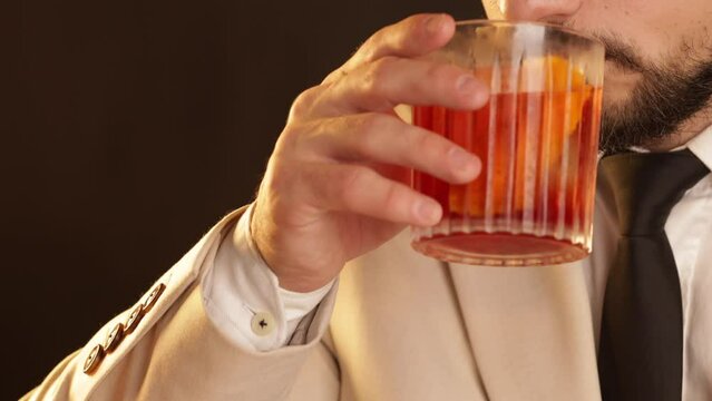 Man drinking a Negroni cocktail