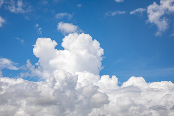 A horizontal shot of bright blue sky with puffy white clouds.